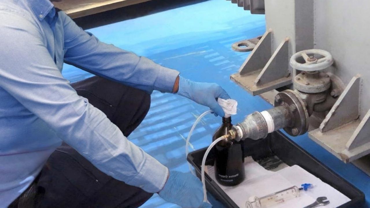Teknisi mengambil sampel air dari sampling point