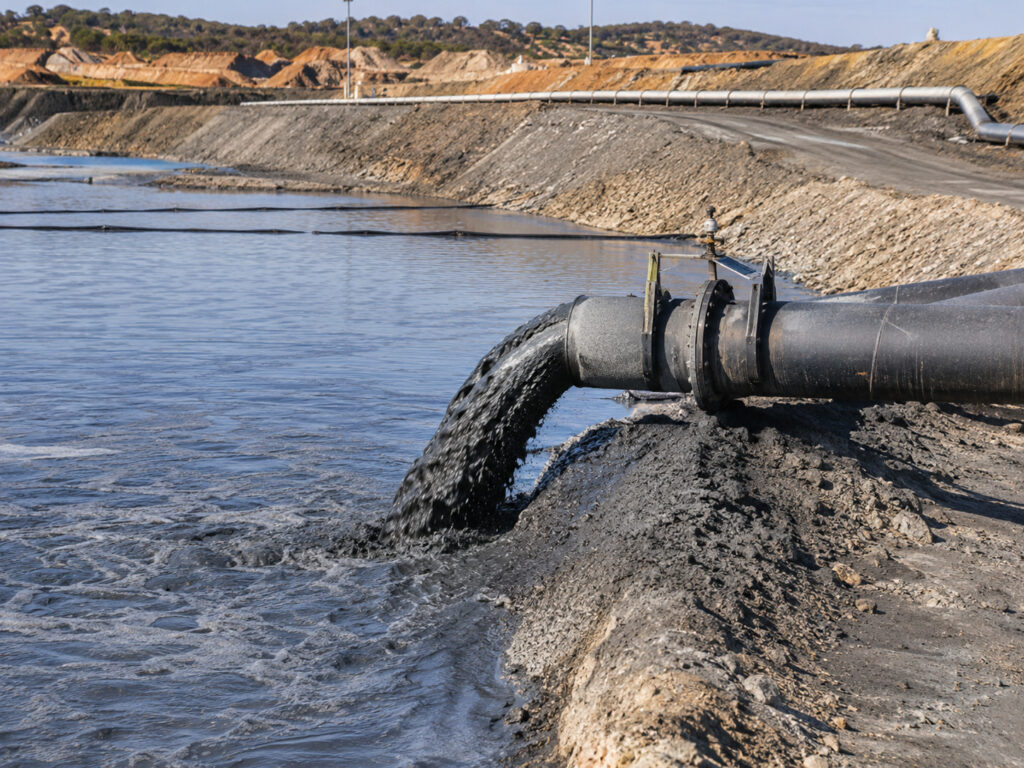 Industrial discharge by a rocky embankment