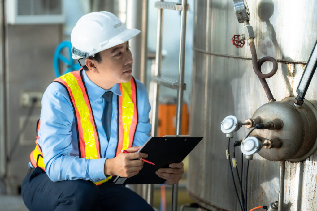 A dedicated quality control engineer in a safety uniform meticul