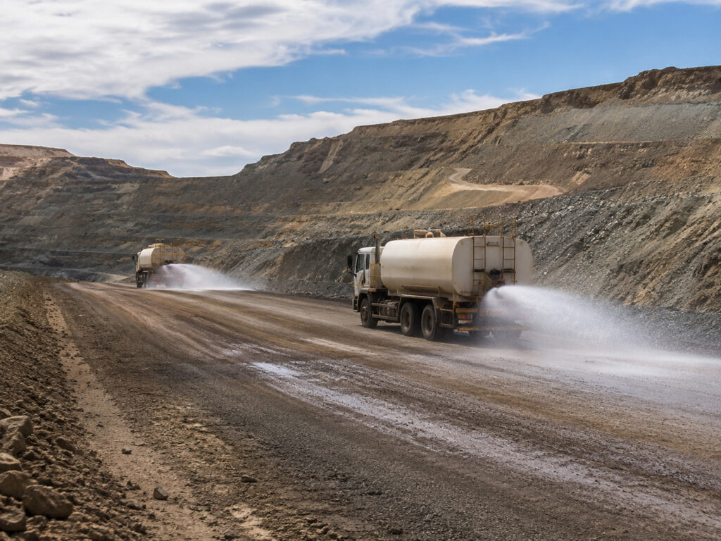 Water trucks in dusty quarry road