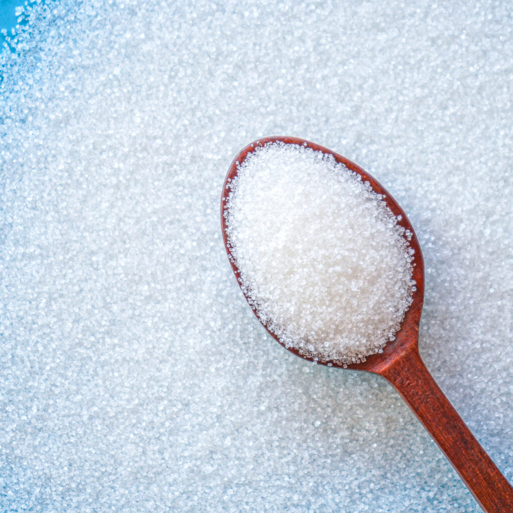 Close up of white sugar in wooden spoon